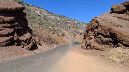 Road amidst rocks against clear sky