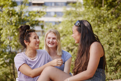 Three young female friends sitting together talking