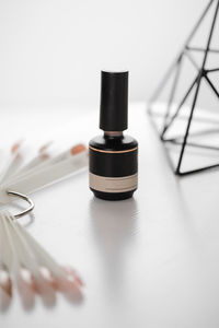 Gel lacquer bottle standing at table. close up view of black bottle of nail polish standing