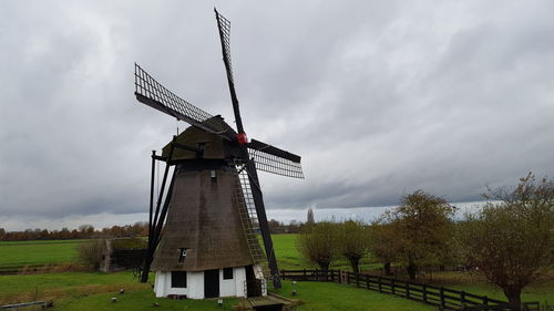 Traditional windmill on field against sky