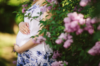 Close-up of pregnant woman standing by plants