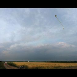 Scenic view of field against cloudy sky