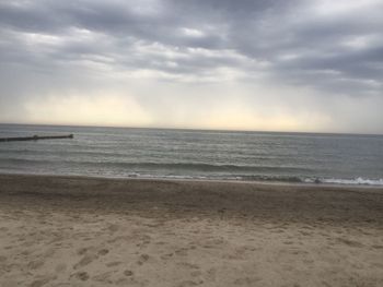 Scenic view of sea against cloudy sky