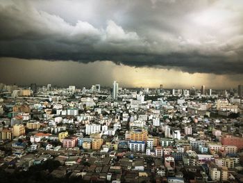 View of cityscape against cloudy sky