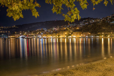 Scenic view of lake against illuminated city at night