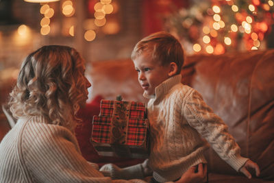 Portrait of happy family mom with small son in knitted beige sweaters