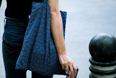 Midsection of woman holding tin can outdoors