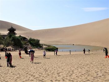 People at beach against sky