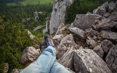 Low section of man sitting on rocks