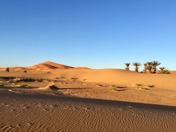 Scenic view of desert against clear blue sky