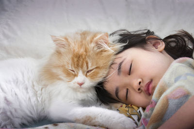 Close-up of cute girl sleeping on bed at home