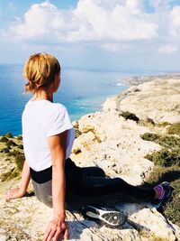 High angel view of woman sitting on rock at beach