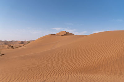 Sand dunes in desert against sky