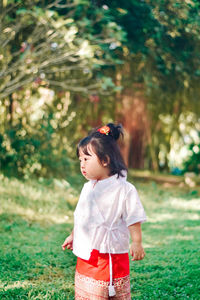 Portrait of young woman standing on field