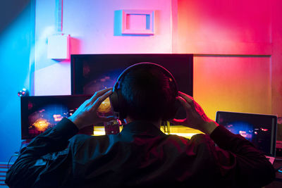 Rear view of man using mobile phone at home