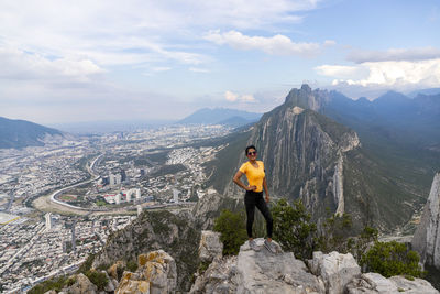 Woman standing on rock against sky