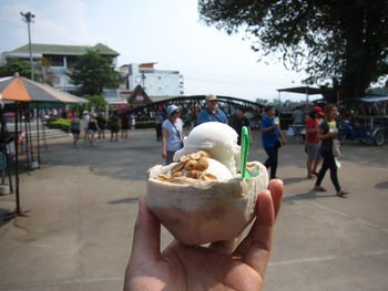 People holding ice cream cone on street