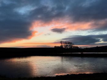 Scenic view of dramatic sky over lake during sunset