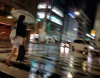 Blurred motion of woman in city at night