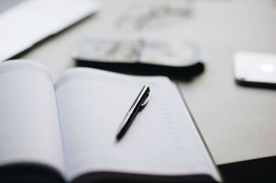 Close-up of pen and book on table