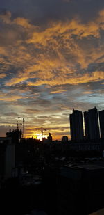 Silhouette buildings against sky during sunset