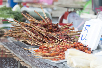 Grilled chickens in container at market for sale