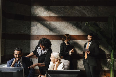 Multiracial male and female financial advisors discussing strategy during meeting at office