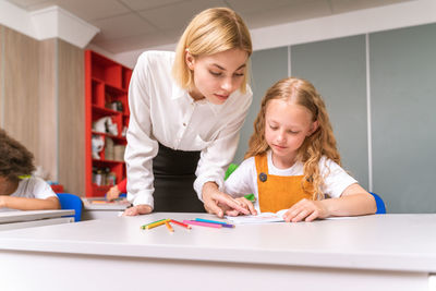 Teacher teaching student at classroom