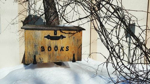 Information sign on tree trunk during winter