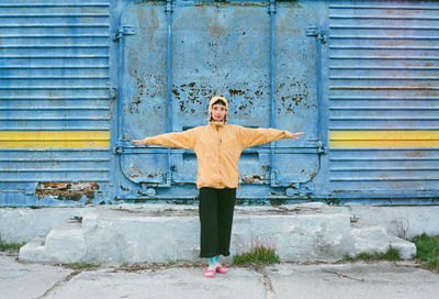 Portrait of woman standing against wall