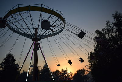 Low angle view of chain swing ride against clear sky