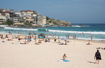 People at beach against clear sky