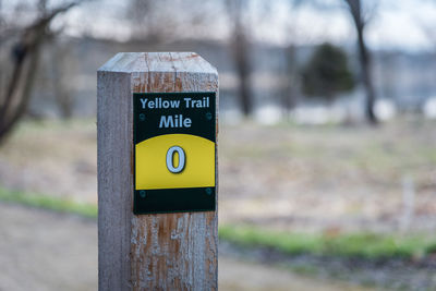 Close-up of signpost along forest trail mile marker zero 0