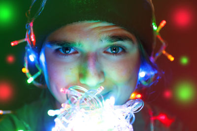 Portrait of a festive young woman with garland on face and head. hipster girl celebrates christmas.