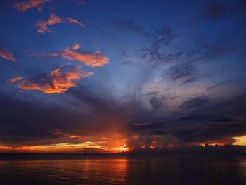 Scenic view of sea against dramatic sky during sunset