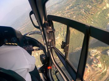 Close-up of pilot in helicopter over landscape