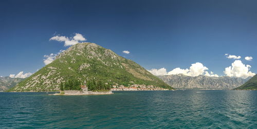 Scenic view of sea and mountains against sky