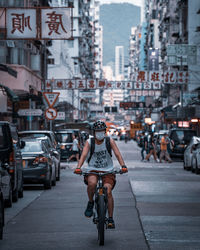 Woman riding bicycle on city street