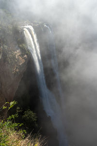 Scenic view of waterfall against sky