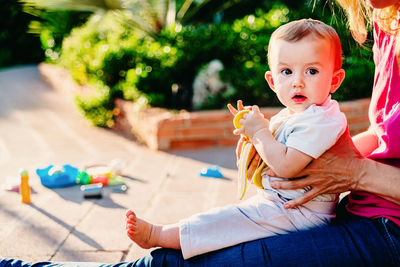 Mother with baby sitting on toy