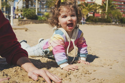 Portrait of boy sitting on sand at beach