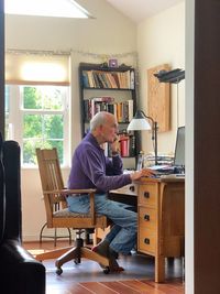 A with it elderly gentleman checks his email and reads the news on a desk top computer. 