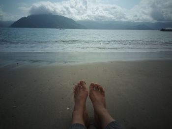 Low section of woman relaxing on beach