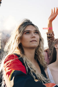 Young woman with friends enjoying music at concert