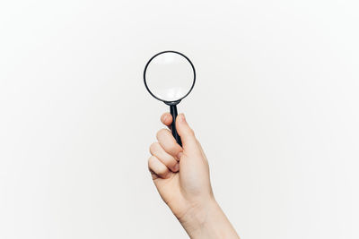 Hand of woman holding magnifying glass