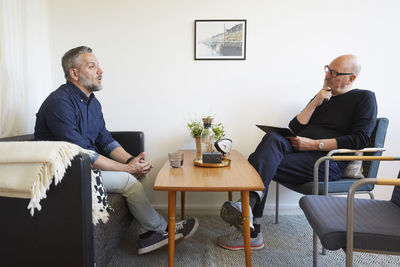 Mature man talking to senior therapist at community center