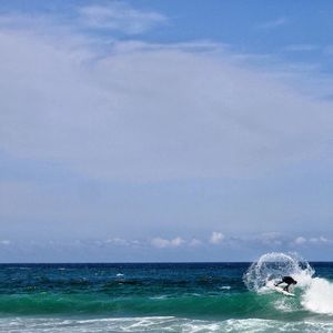 Man swimming in sea against sky