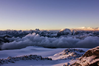 Scenic view of snowcapped mountains against sky at sunset