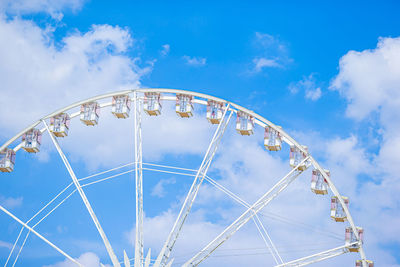 Low angle view of ferris wheel against blue sky