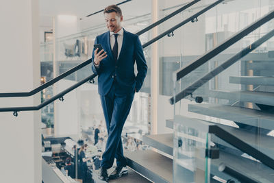 Low angle view of businessman walking on escalator